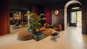 A modern lobby with a bar area, seating, and a large plant. - Flaner Hotel, WorldHotels Crafted (Warsaw)