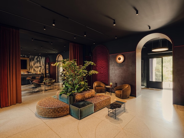 A modern lobby with a bar area, seating, and a large plant. - Flaner Hotel, WorldHotels Crafted (Warsaw)