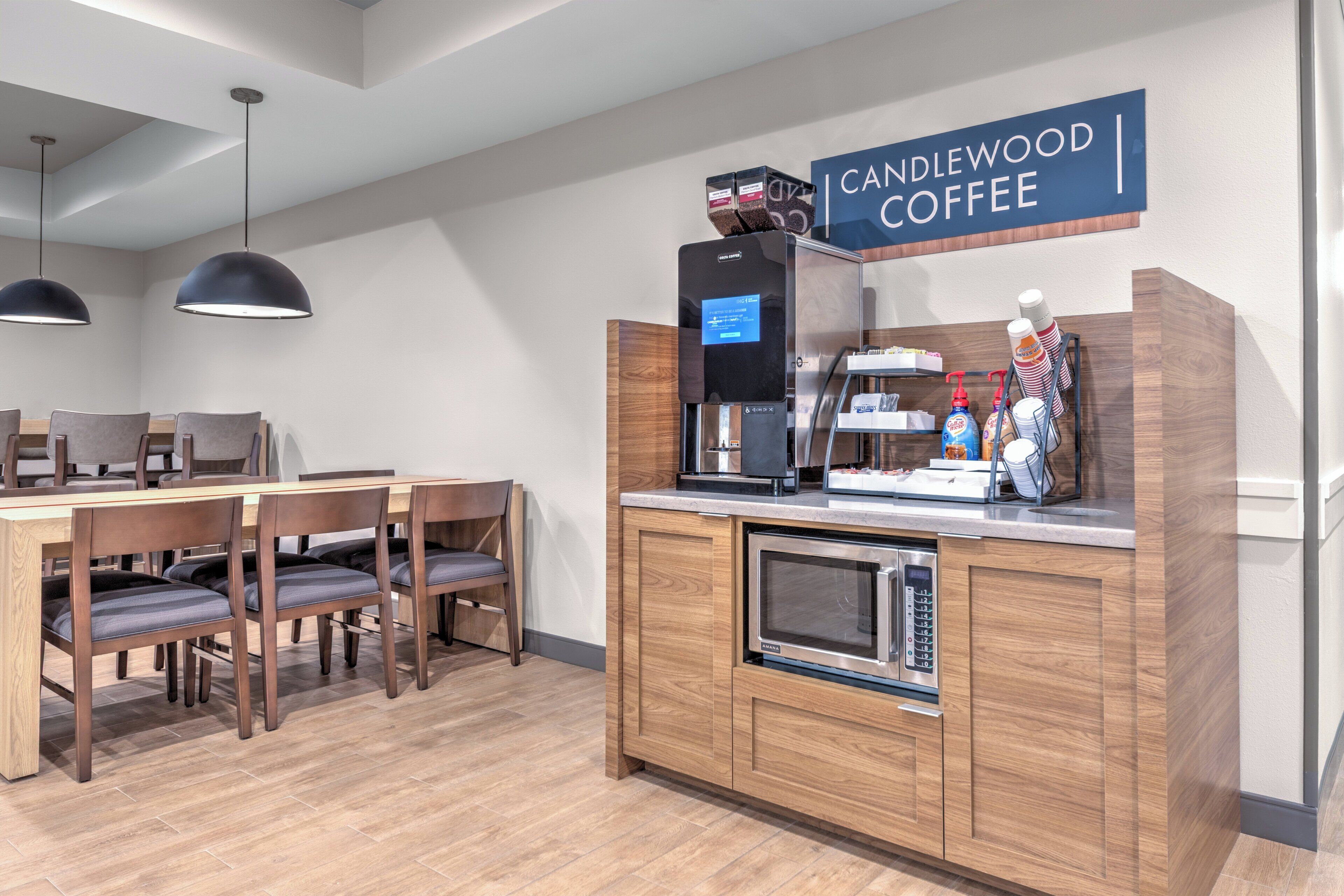 A modern coffee station with a coffee machine, a coffee dispenser, and a sign that reads "CANDLEWOOD COFFEE".