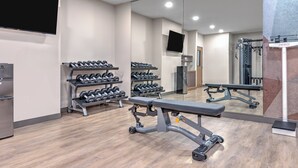 A gym with weightlifting equipment, dumbbells, and a bench. - Candlewood Suites Navasota by IHG (Navasota)