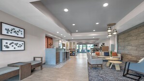A spacious lobby with a reception desk, seating areas, and a patterned rug. - Candlewood Suites Navasota by IHG (Navasota)