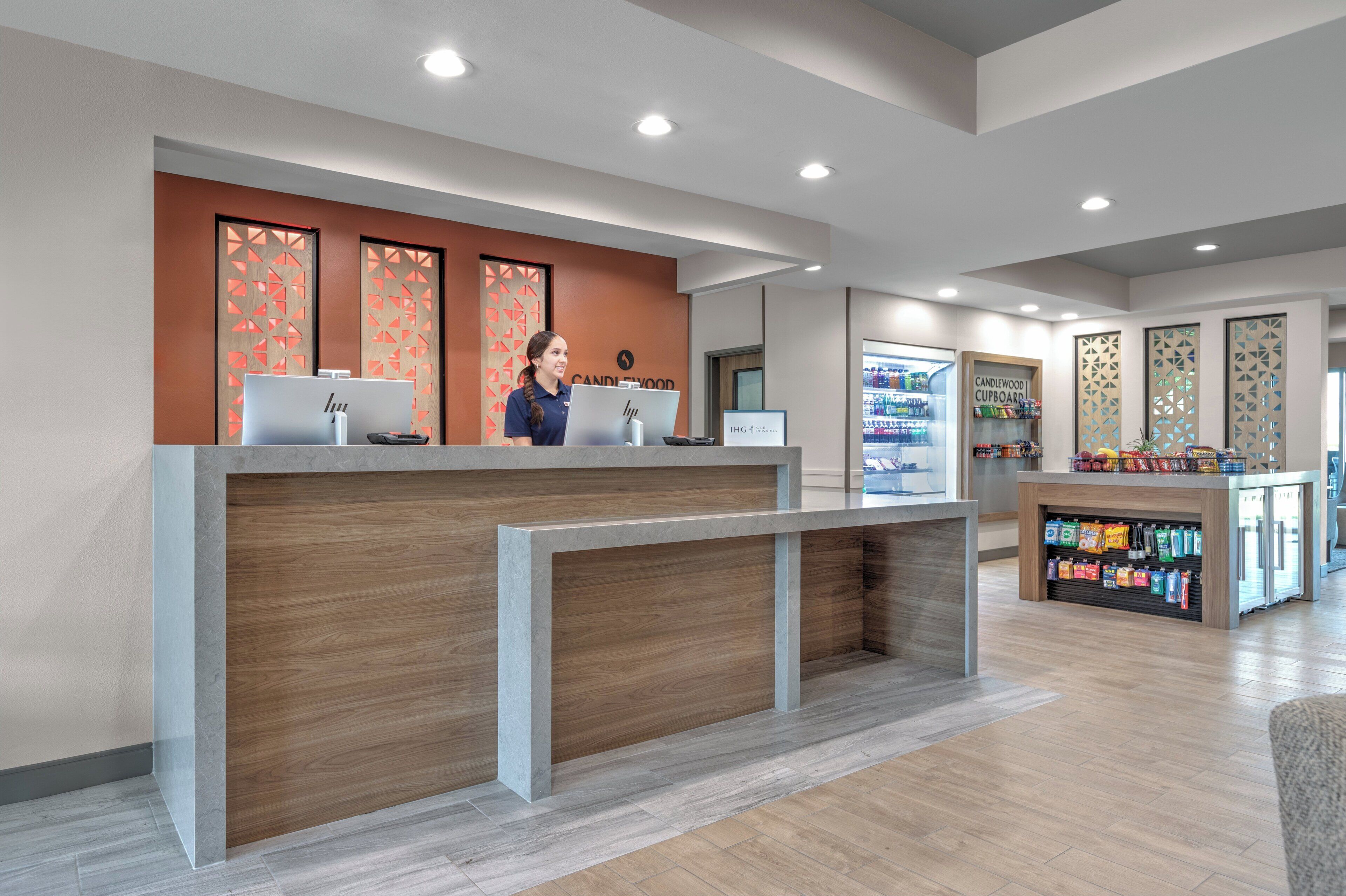 A reception area with a wooden reception desk, computers, and a display of products.