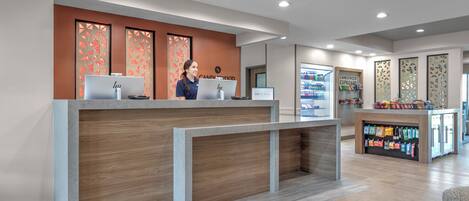 A reception area with a wooden reception desk, computers, and a display of products.