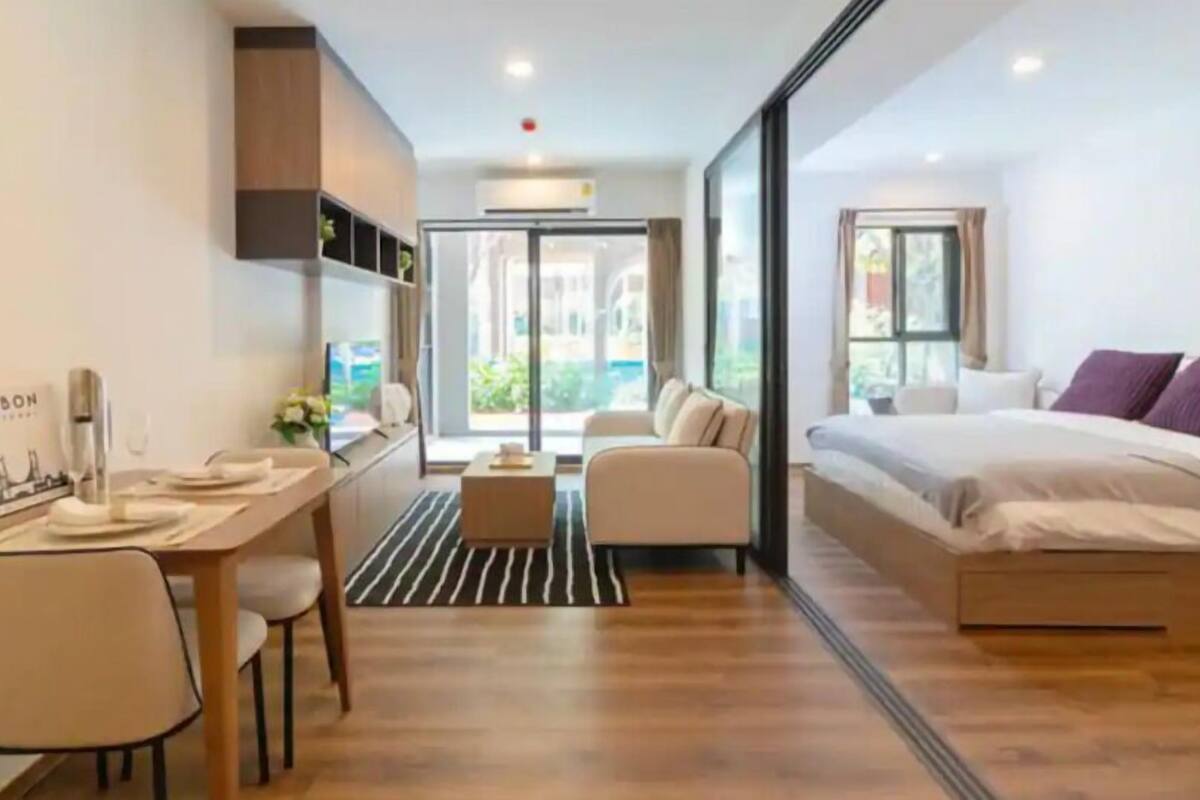Una habitación de hotel moderna con una cama, un escritorio y una zona de estar.