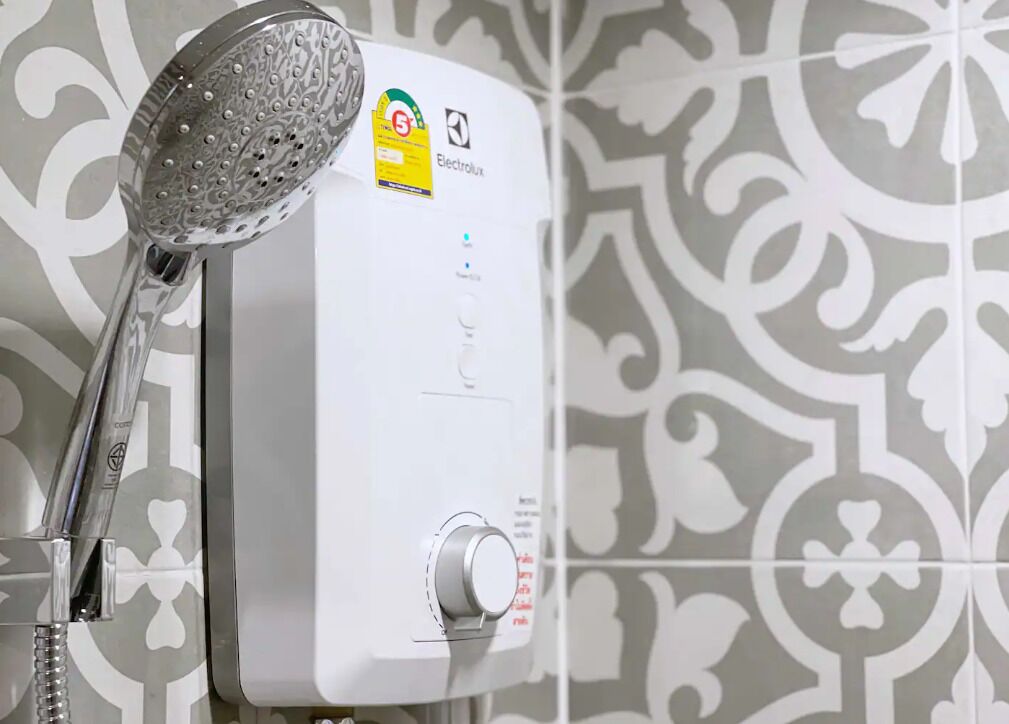 A modern bathroom with a handheld showerhead attached to a wall-mounted unit.