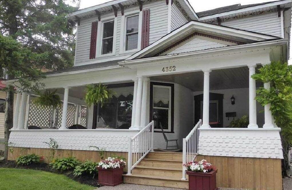 A two-story house with a covered porch and a front door.
