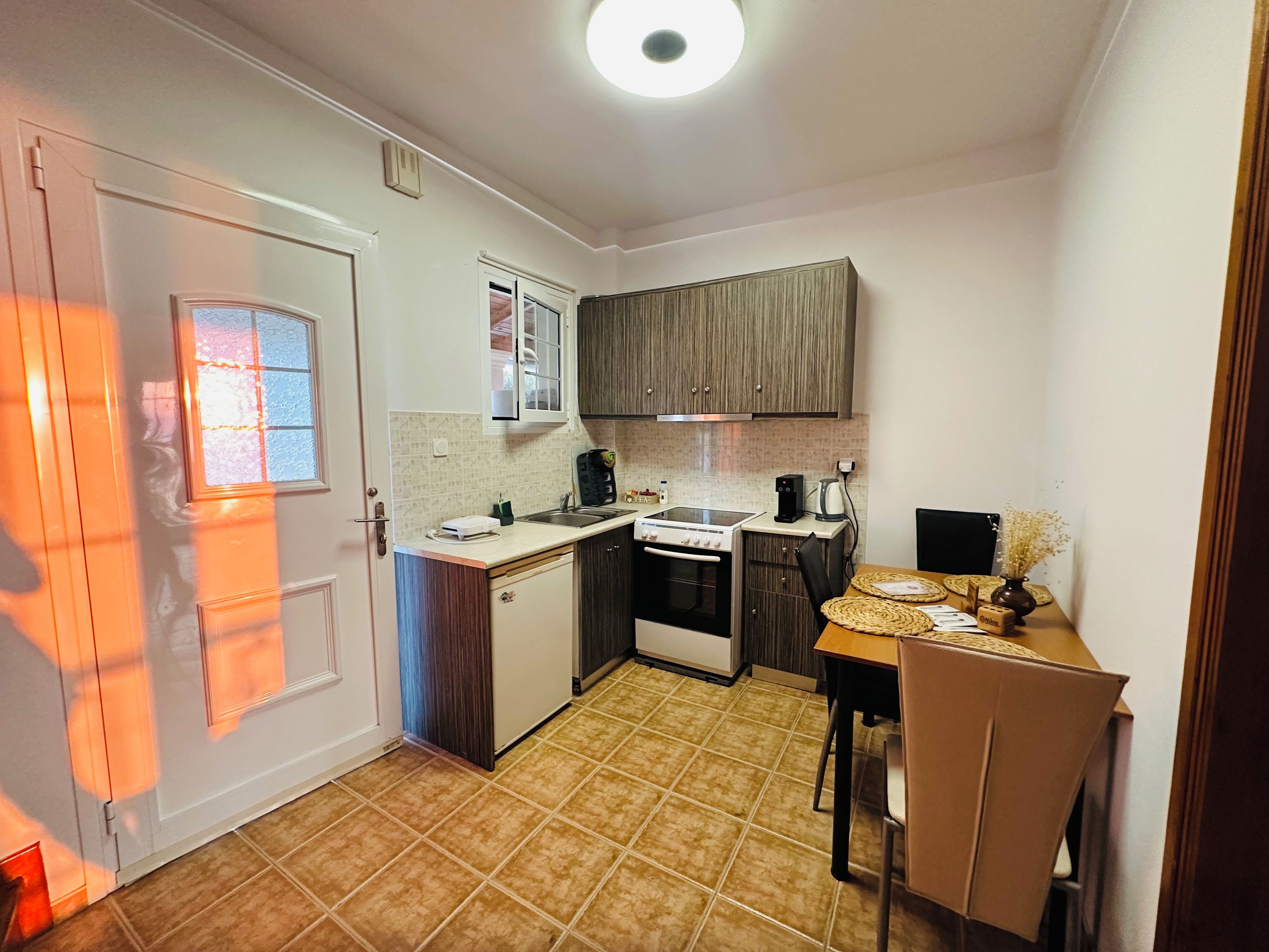 A compact kitchen with a stove, sink, and cabinets.