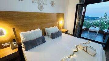 A hotel room with a large bed, two bedside lamps, a wooden headboard, and a view of a balcony with outdoor furniture.