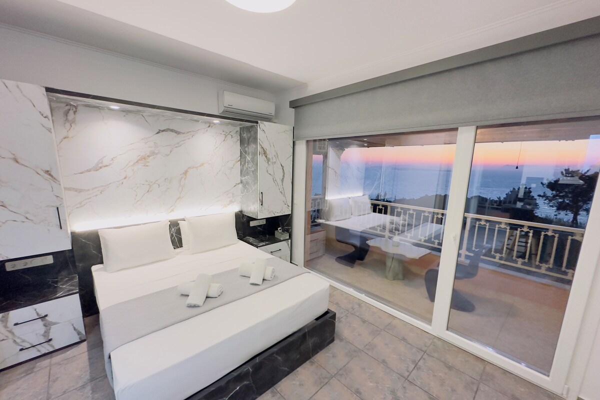 Un dormitorio moderno con una cama grande, una pared de mármol y un balcón con vistas.