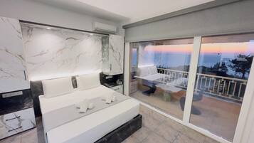 Un dormitorio moderno con una cama grande, una pared de mármol y un balcón con vistas.