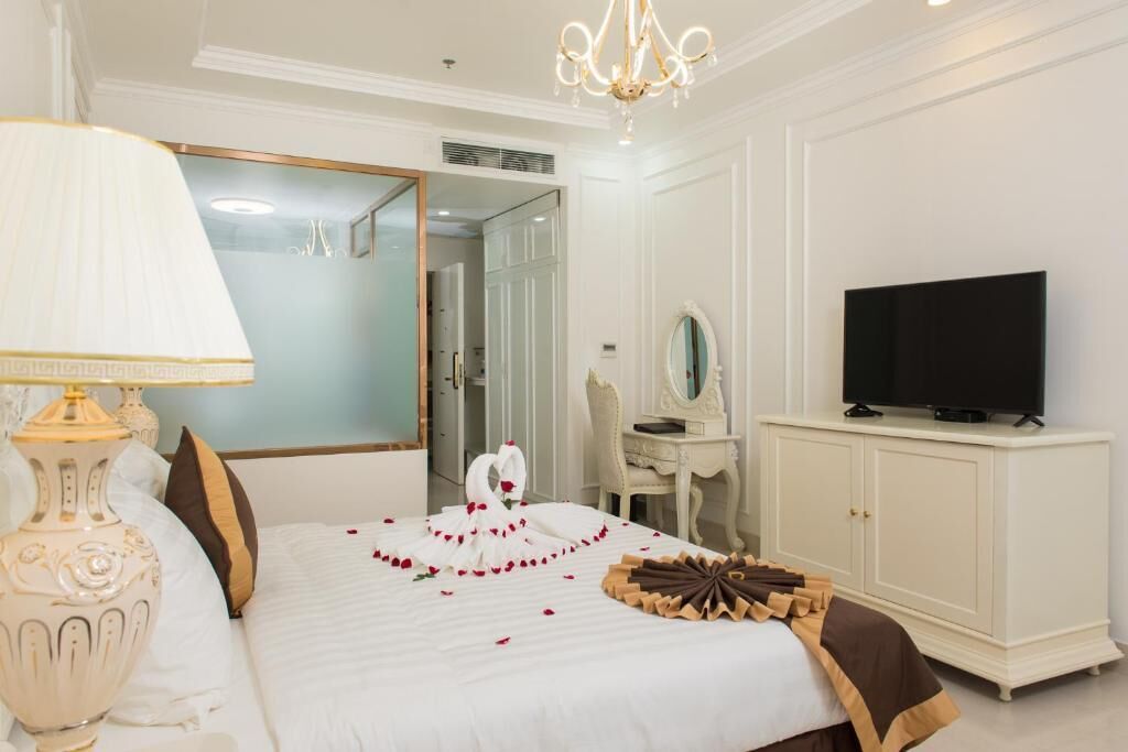 Une chambre d’hôtel avec un lit, une télévision, une commode et un miroir.