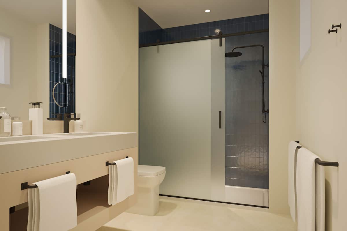 A modern bathroom with a glass-enclosed shower, a white toilet, and a vanity with a mirror and towel racks.