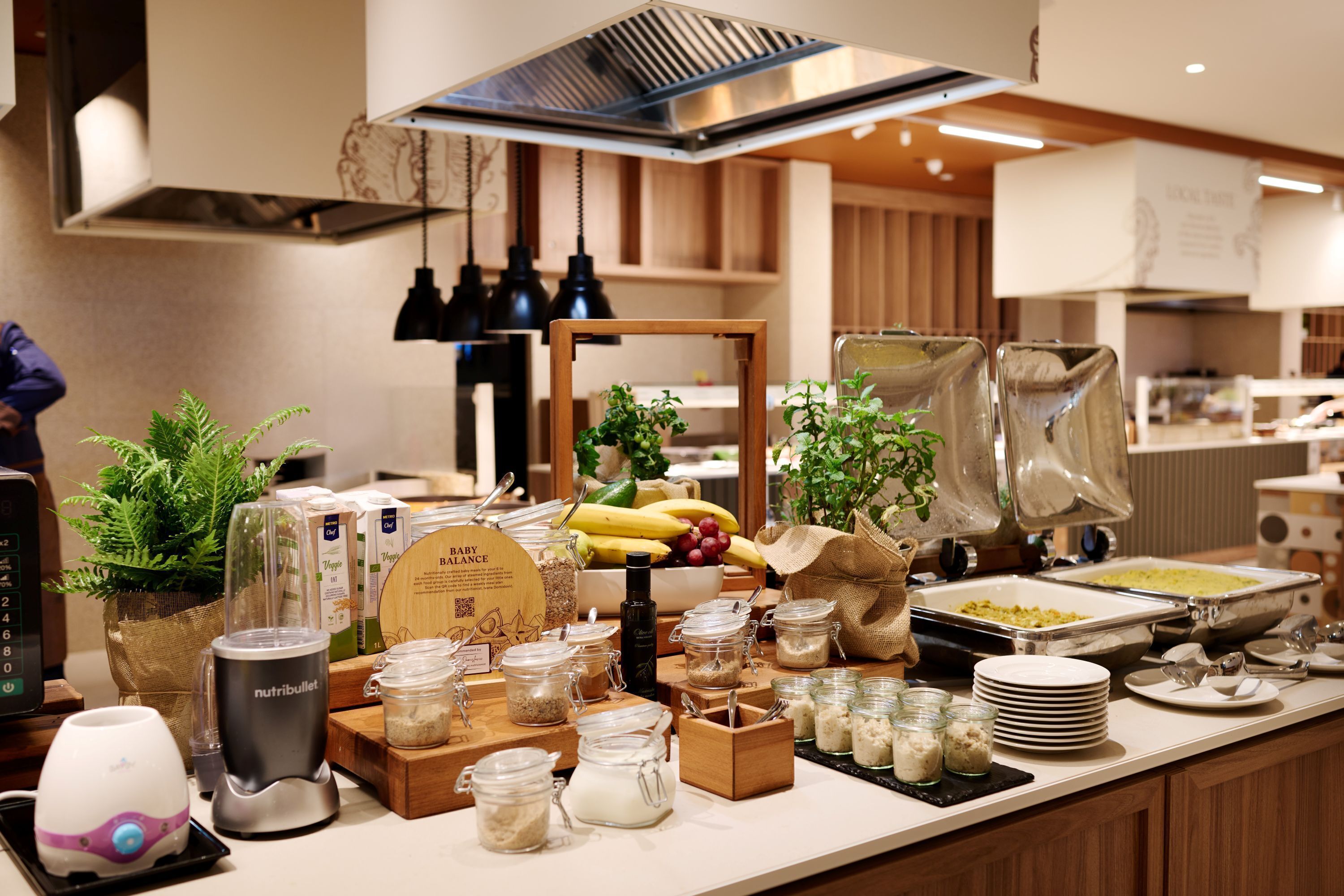 A buffet setup with various food items, a blender, and multiple serving dishes.