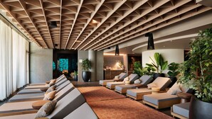 A modern lounge area with multiple seating options, a patterned carpet, and large potted plants. - Arba Resort, Valamar Collection (Rab)