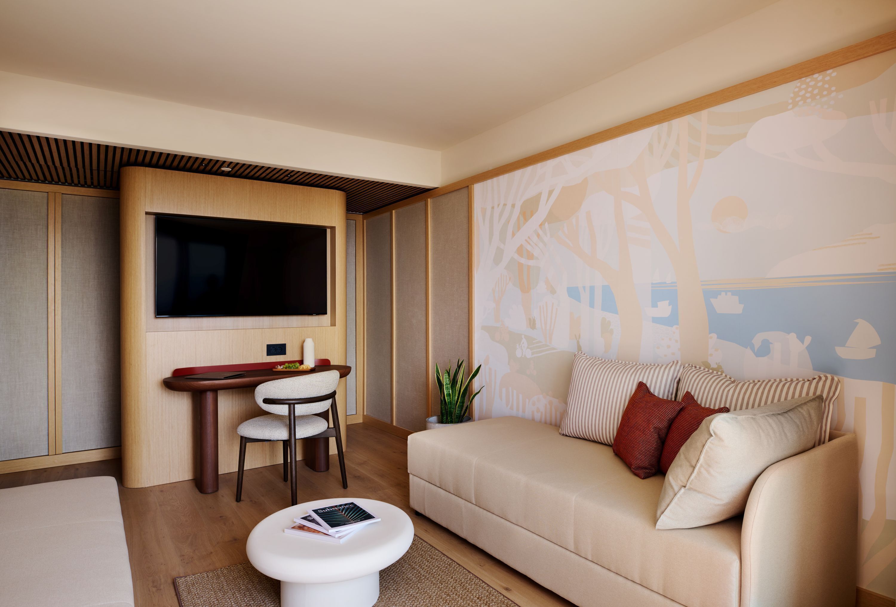 Un salon moderne doté d’un téléviseur à écran plat, d’un canapé, d’une table à manger avec des chaises et d’un mur décoratif.