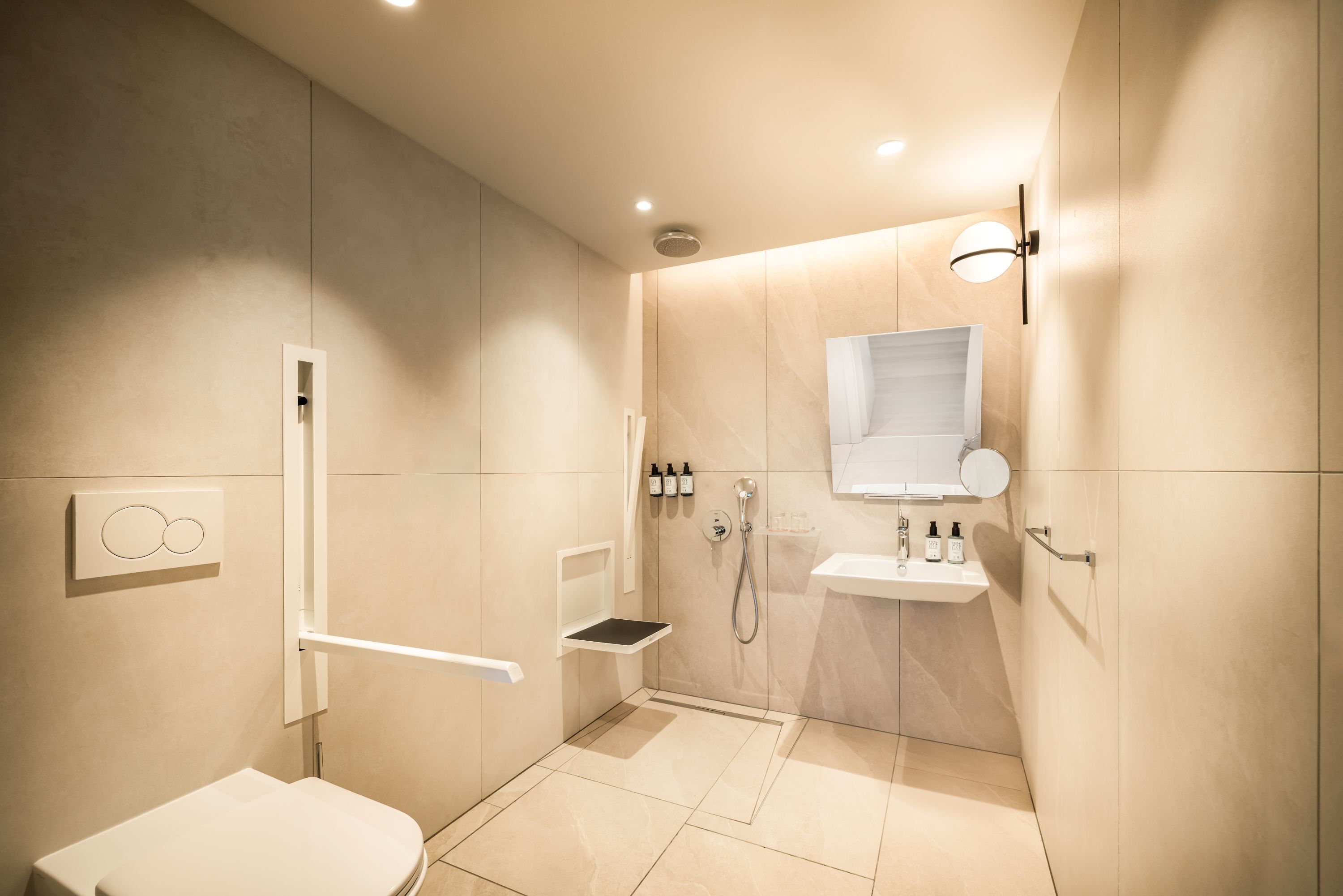 A modern bathroom with a shower, toilet, and sink, featuring a minimalist design and neutral color palette.