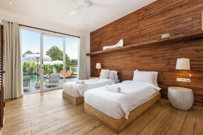 Habitación de hotel moderna con dos camas, piso de madera, un gran ventanal corredero a un área de piscina exterior y una pared de madera con estanterías.