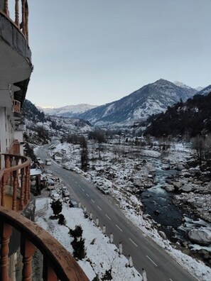 A mountain road with snow-covered landscape and a river. - Hotel Royal Grand - Manali (Manali)