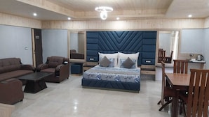 Quarto moderno com uma cama grande, um sofá, uma mesa de centro e um espaço de jantar.