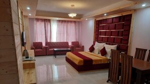 Um quarto com uma cama, um sofá, uma mesa de jantar e cadeiras.