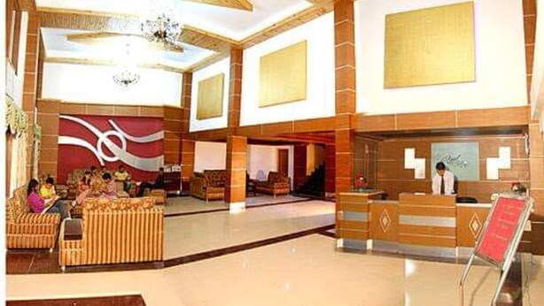 Um hall amplo com balcão de atendimento, área de estar e parede decorativa.