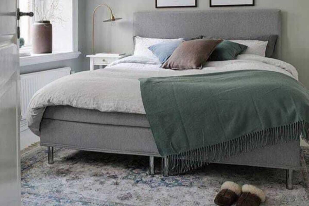Un dormitorio con una cama, una ventana con vistas y una pared decorada con dos cuadros.