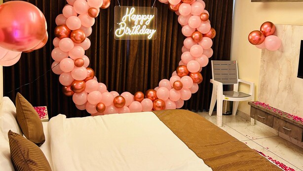 A hotel room with a bed, a chair, a desk, and a neon sign reading "Happy Birthday". - HOTEL MAGNET - INDORE (Indore)
