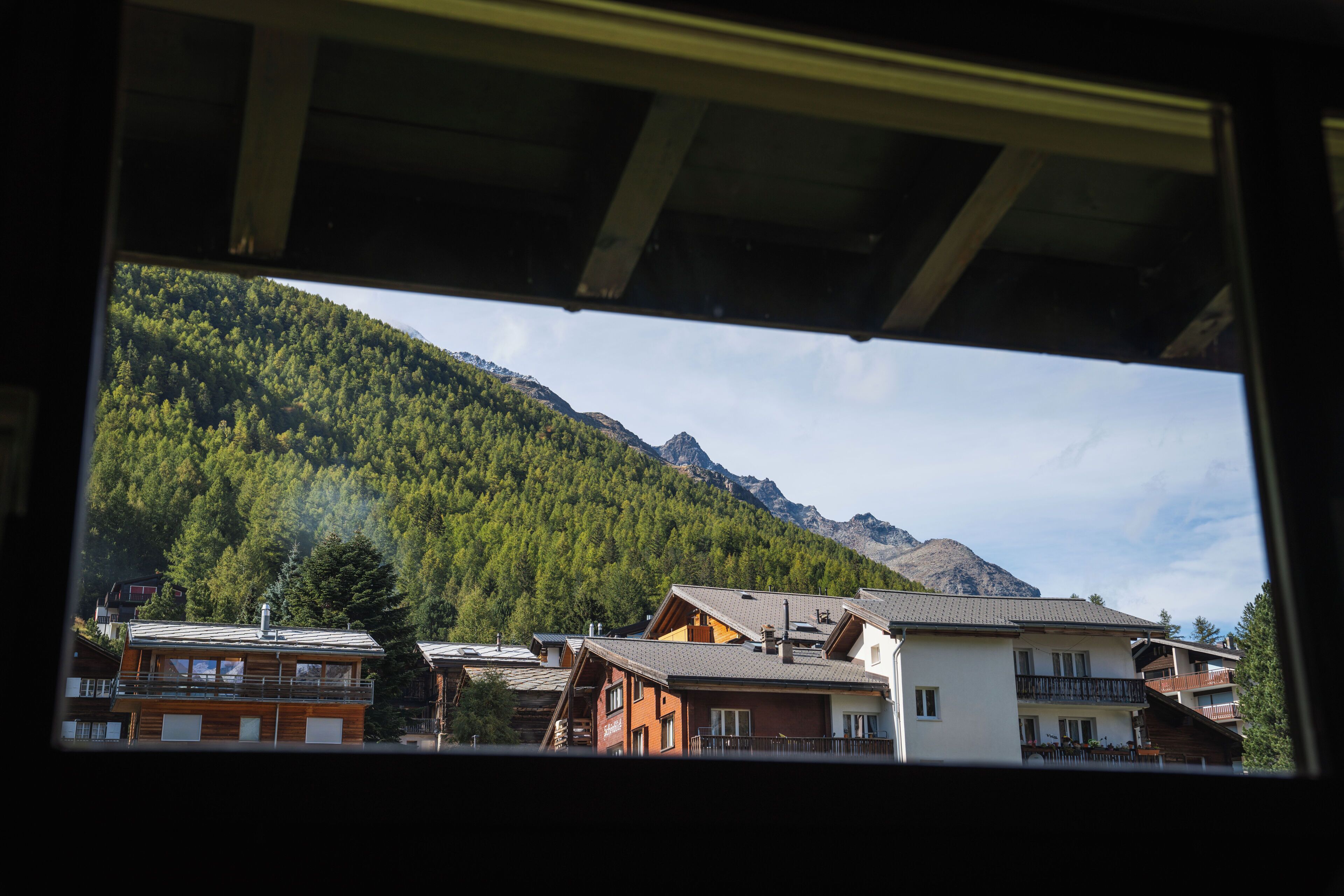 A mountain landscape with buildings in the foreground.