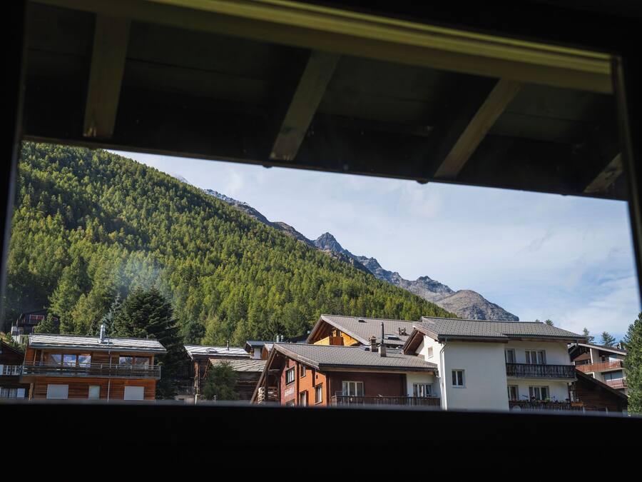A mountain landscape with buildings in the foreground.