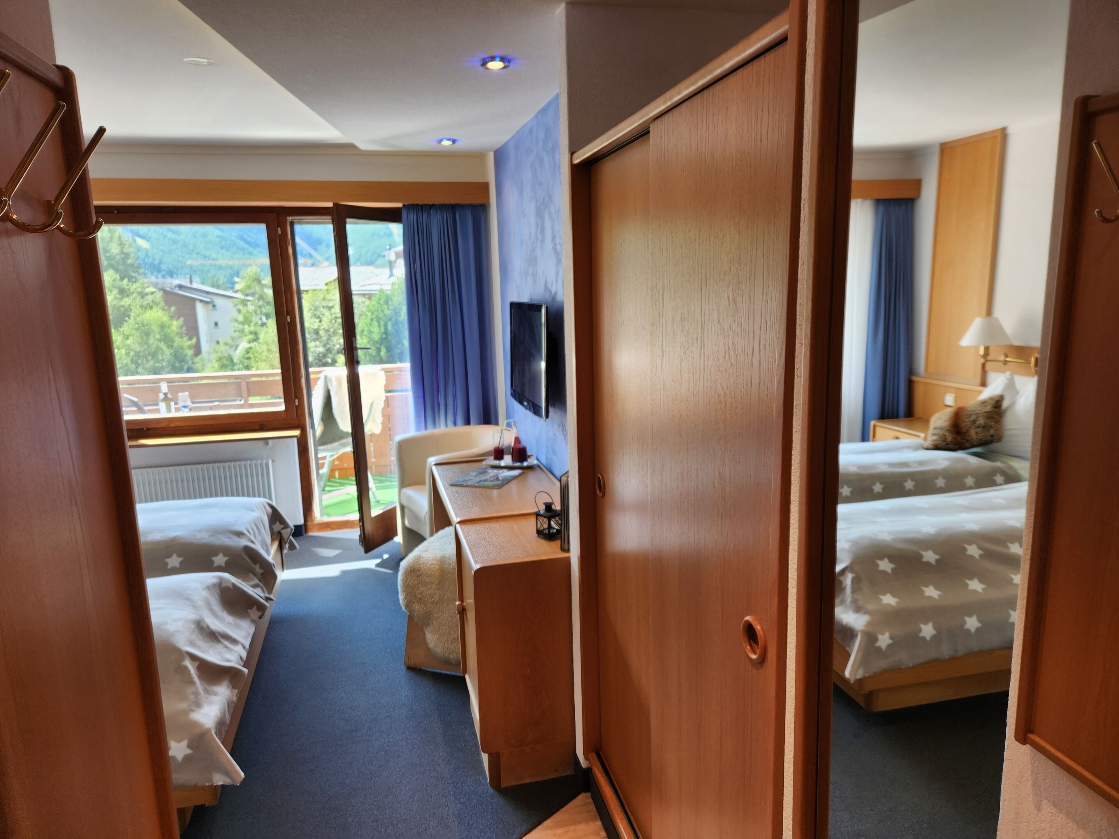 Une chambre d’hôtel équipée d’un lit, d’un bureau, d’une chaise, d’une télévision et offrant une vue sur l’extérieur.