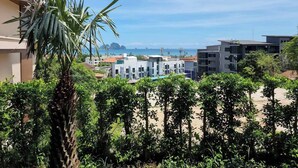 Ein Wohngebiet mit modernen Gebäuden, freiem Blick auf das Meer und üppigem Grün.