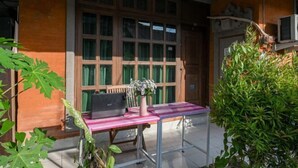 Una habitación con un amplio ventanal, un escritorio con una computadora portátil y una planta en maceta.