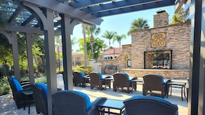 An outdoor patio area with wicker furniture and a stone wall. - Stop Scrolling - FREE Water Park Access - Newly Renovated Family Resort Home (Kissimmee)