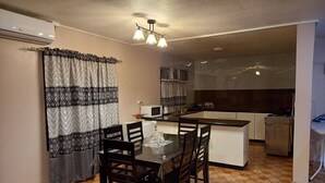 Una cocina compacta con comedor, microondas y pileta.