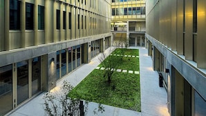 Un bâtiment moderne doté d’une cour intérieure, de grandes fenêtres et d’un toit plat.