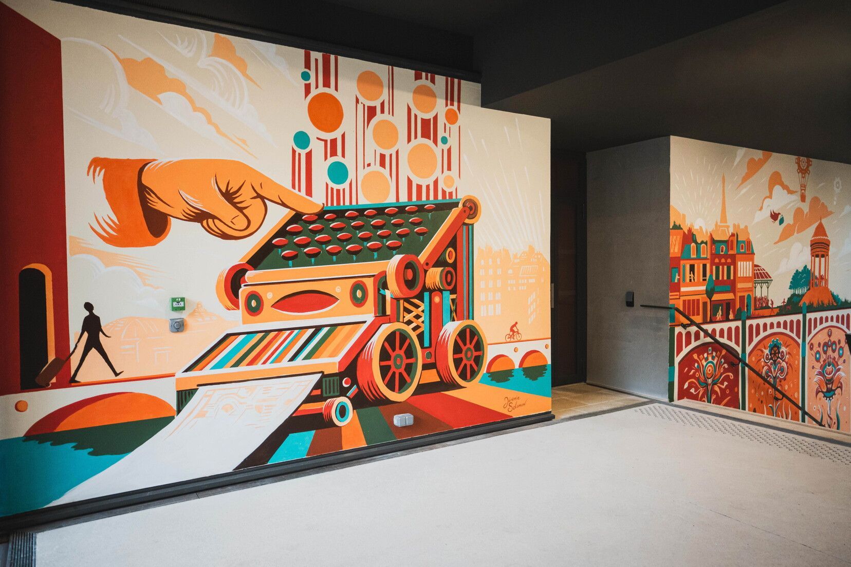 A mural with a large hand pointing at a colorful, abstract machine.