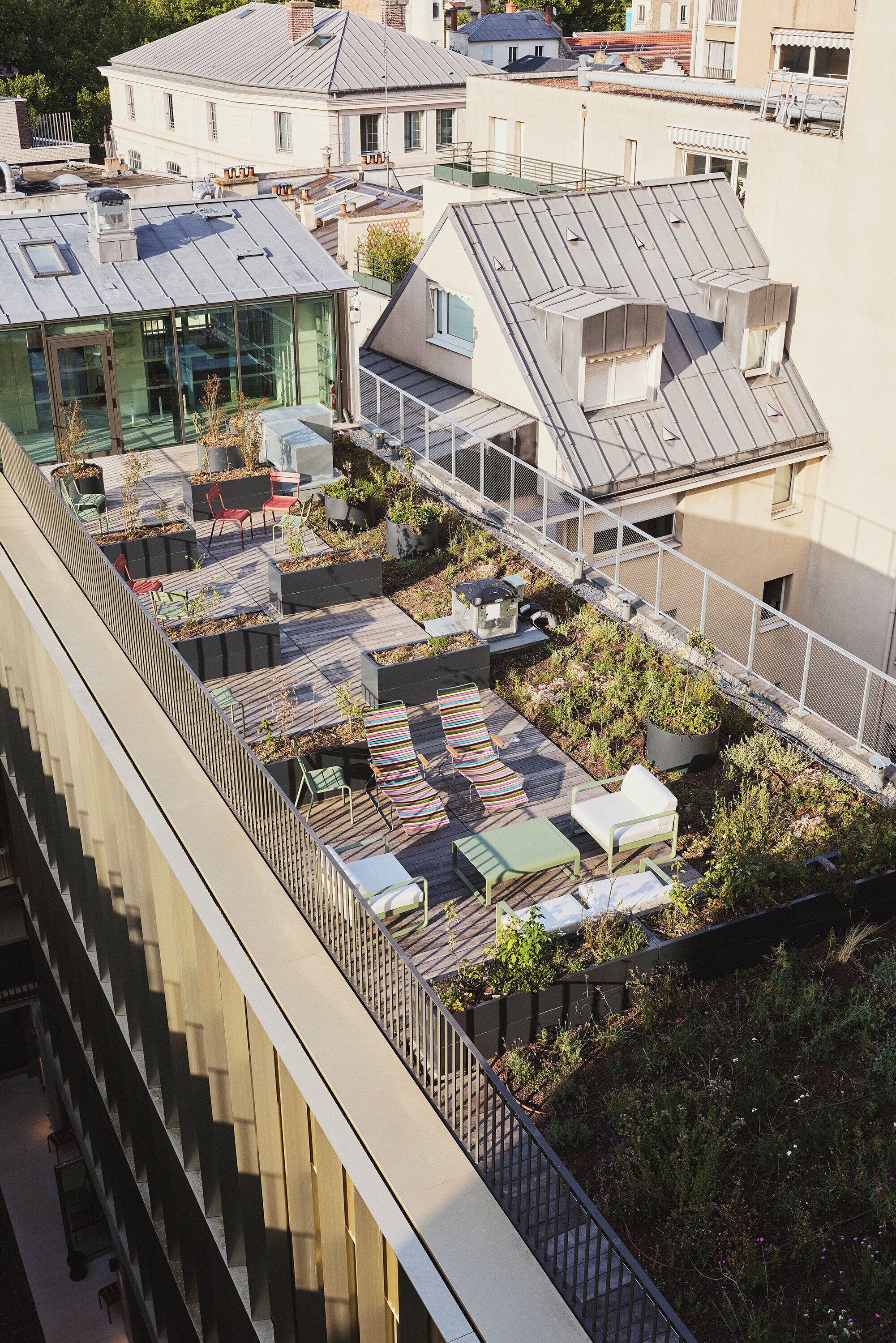 A rooftop garden with seating areas and potted plants.