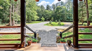 A wooden structure with a gravel path leading to a forested area.