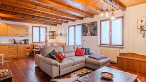 A cozy living room with a sofa, a dining area, and a kitchen. - Apartment Ermeti by Interhome (Valle di Non)
