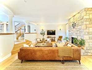 A living room with a sofa, coffee table, and fireplace.