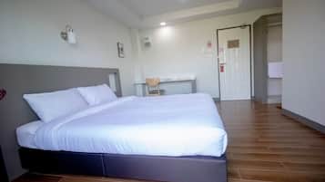 Een slaapkamer met een bed, een bureau en een stoel.