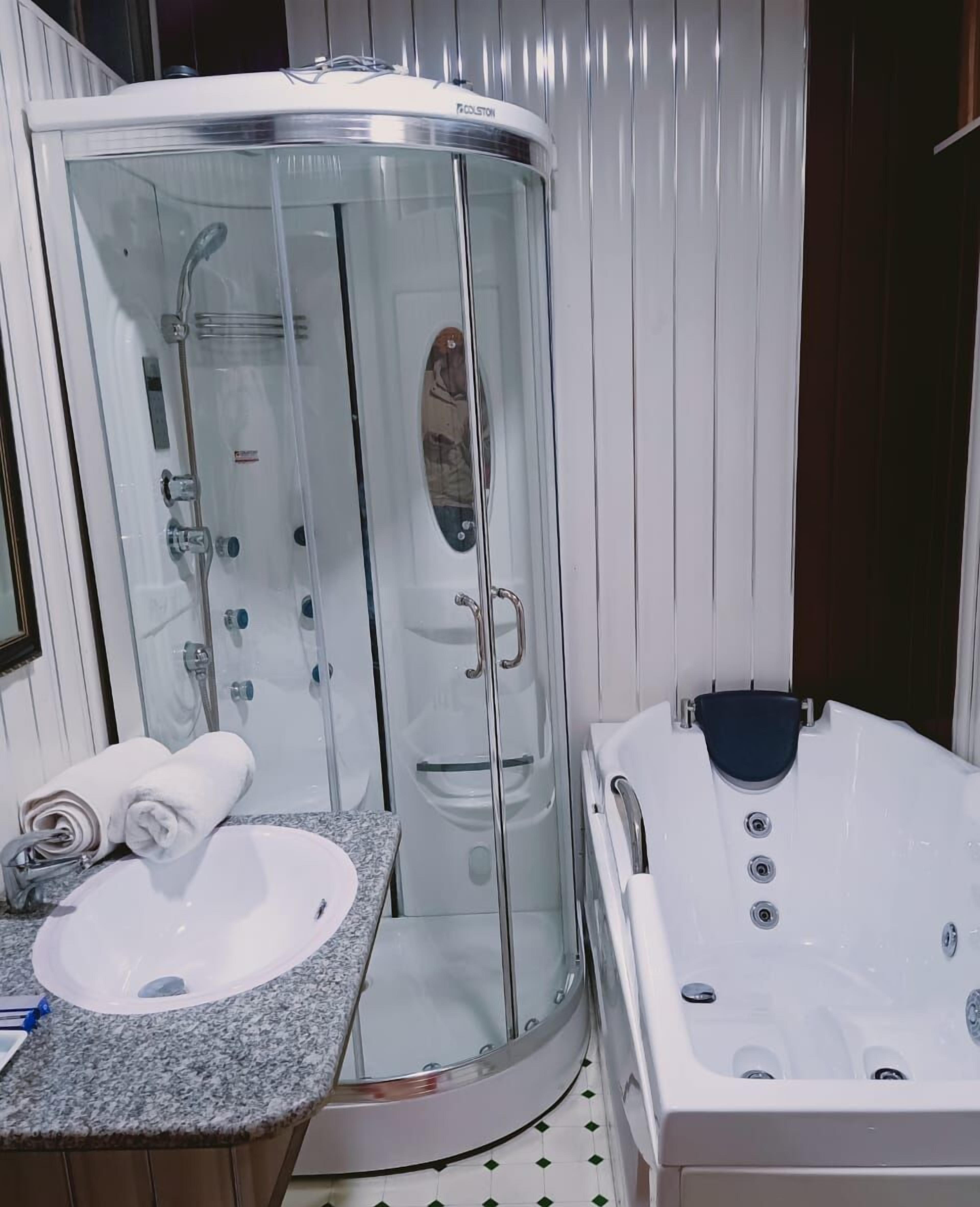 Separate tub and shower, hair dryer, slippers, towels