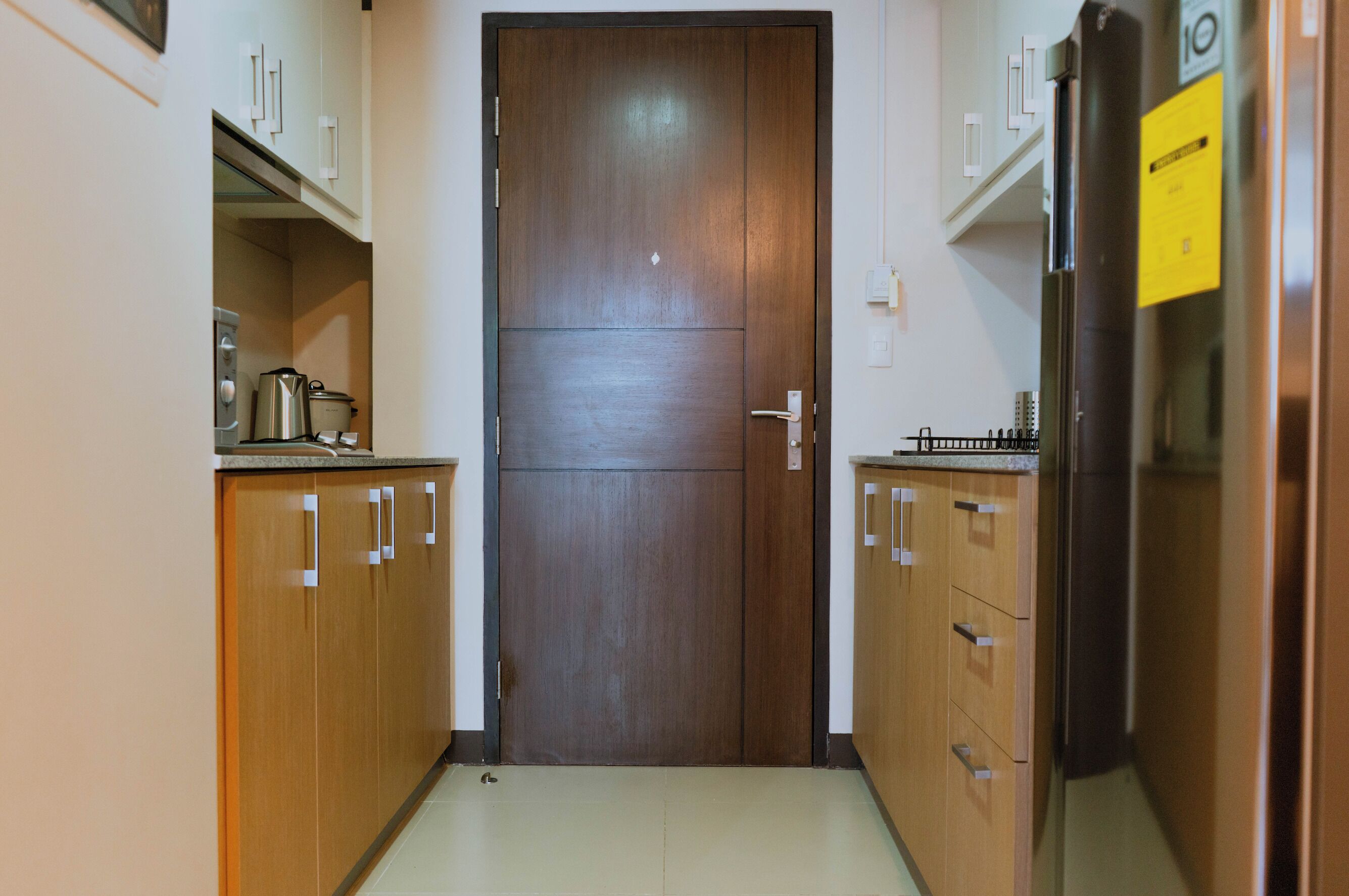 Una cocina estrecha con armarios de madera, un refrigerador y una estufa.