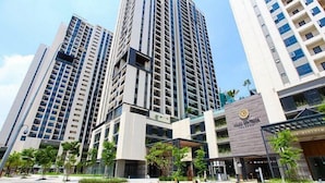 Un moderno edificio de gran altura con varios pisos, ventanas amplias y un patio central con vegetación.