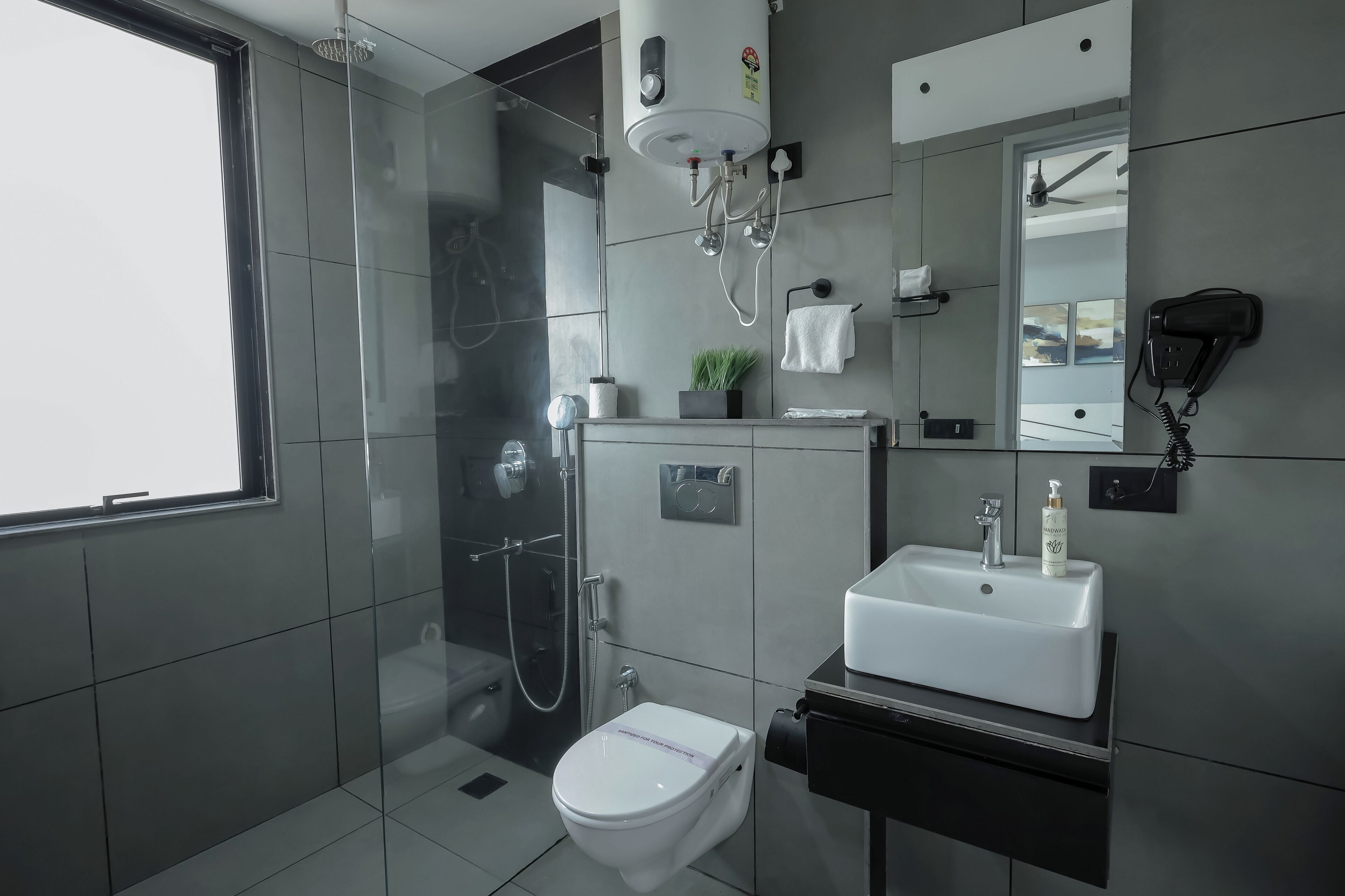 A modern bathroom with a toilet, sink, and shower.
