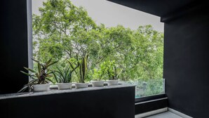 Ein Balkon mit Blumentöpfen und Blick auf üppiges Grün.