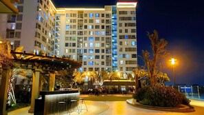 A modern hotel with multiple floors, outdoor seating area, and well-lit surroundings. - The Parkview - Very Close TSN Airport (Ho Chi Minh City)