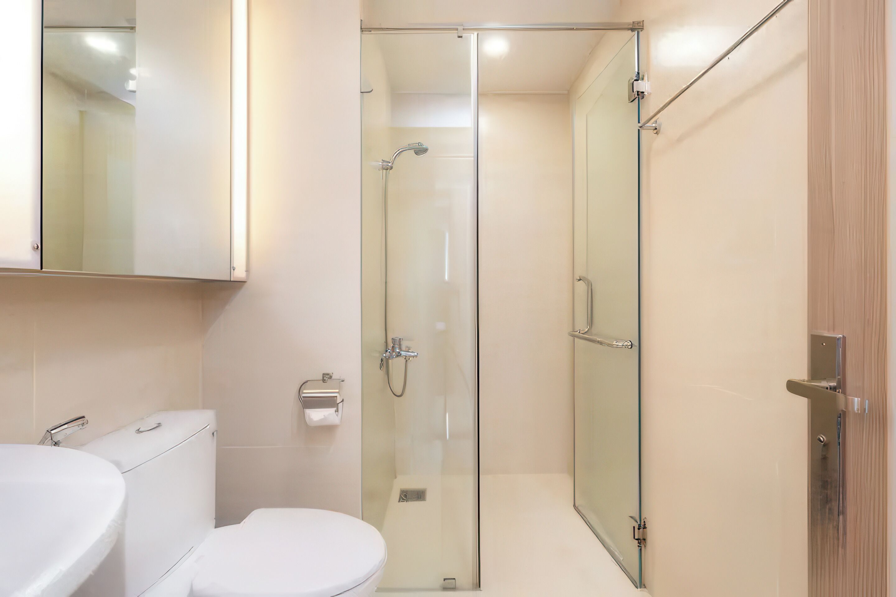 A modern bathroom with a glass-enclosed shower, a white toilet, and a sink.