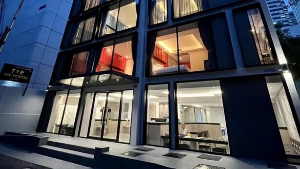 Un hôtel moderne doté d’une façade en verre, de plusieurs étages et d’une enseigne indiquant qu’il s’agit de « The Portal ».