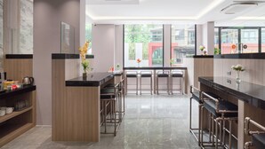 Une cuisine moderne dotée d’un îlot central, de tabourets de bar et offrant une vue sur l’extérieur.